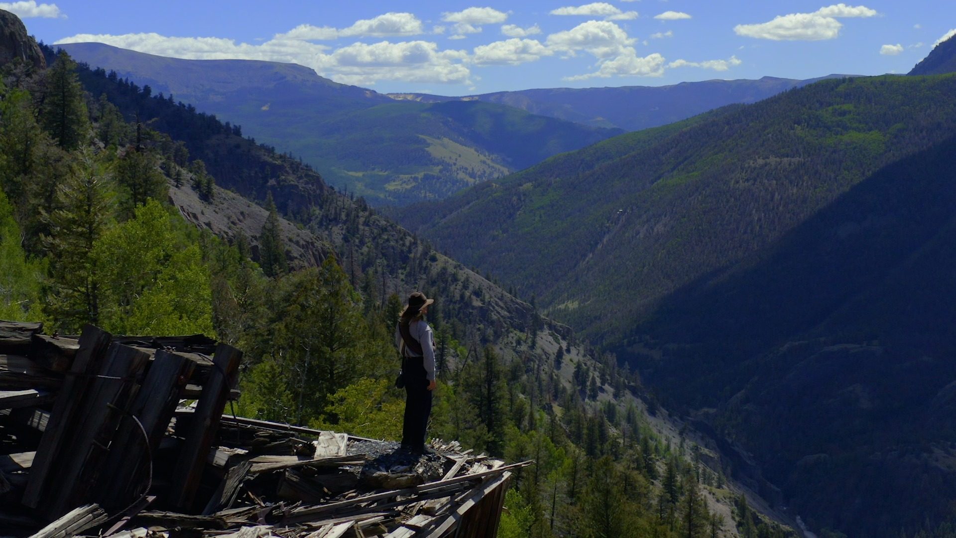 Figure atop ruins above a canyon